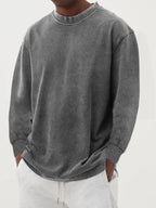 Close-up of a grey washed oversized jumper highlighting the ribbed cuff and dropped shoulder seam