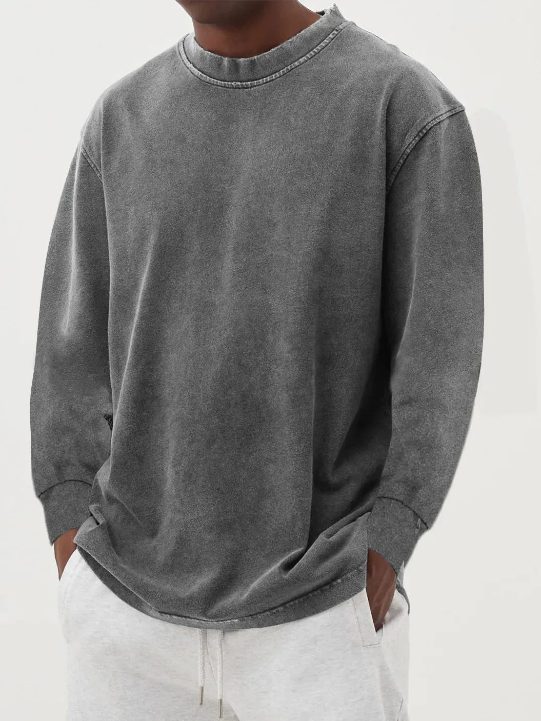 Close-up of a grey washed oversized jumper highlighting the ribbed cuff and dropped shoulder seam