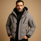 Grey quilted puffer jacket with contrast black trim, zip pockets and an arm sleeve pocket, front view.