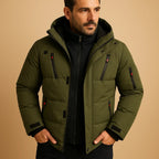 Olive green puffer jacket with hood, zip pockets and ribbed cuffs, worn with a black polo neck jumper.