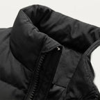 Close-up of the zip pull and collar on a navy blue quilted gilet