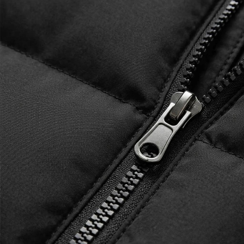 Detail of the zipped side pocket and quilted stitching on a navy blue padded gilet