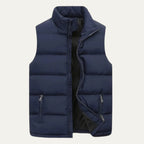 Front view of a navy blue quilted gilet, unzipped, with stand collar and twin zipped pockets