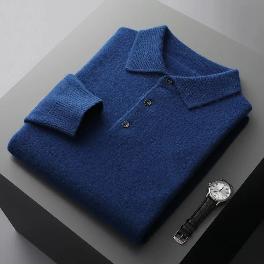 Folded blue cashmere polo jumper with ribbed collar, button placket and cuffs shown beside a wristwatch