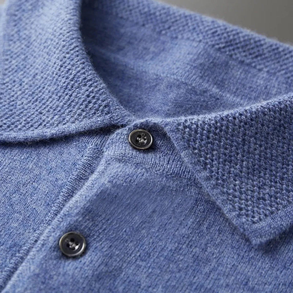 Black polo jumper folded neatly with visible ribbed texture across the body panel
