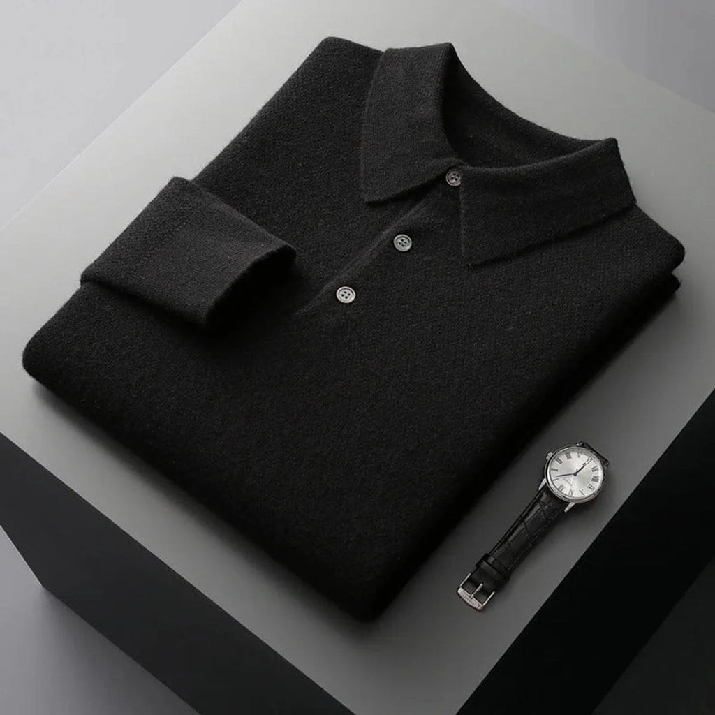 Folded black cashmere polo jumper with matching buttons and ribbed collar on a dark backdrop