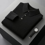Folded black cashmere polo jumper with matching buttons and ribbed collar on a dark backdrop