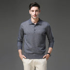 Man wearing a charcoal grey polo neck jumper with button placket, styled with cream trousers