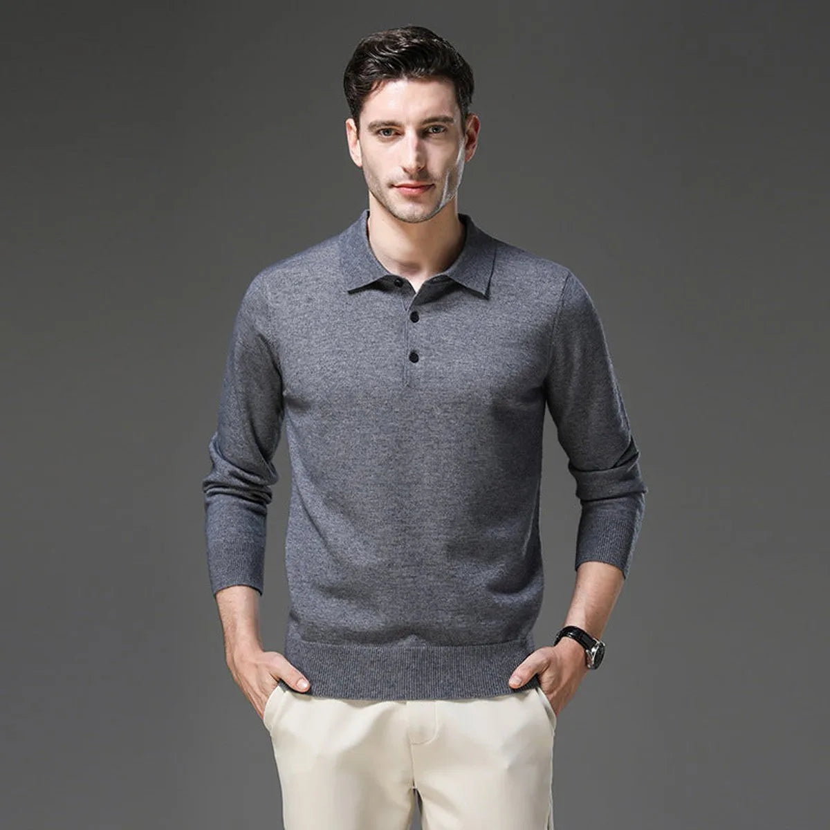 Man wearing a charcoal grey polo neck jumper with button placket, styled with cream trousers