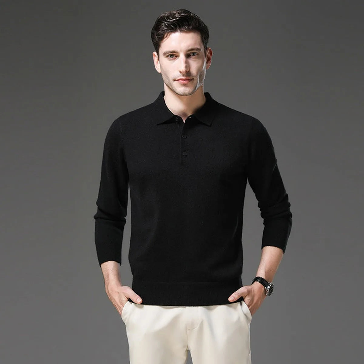 Man wearing a black polo neck jumper with collar and buttons, paired with cream trousers