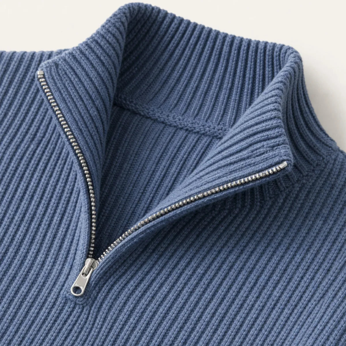 Close-up of the stand collar and half-zip detail on the navy blue ribbed knit jumper
