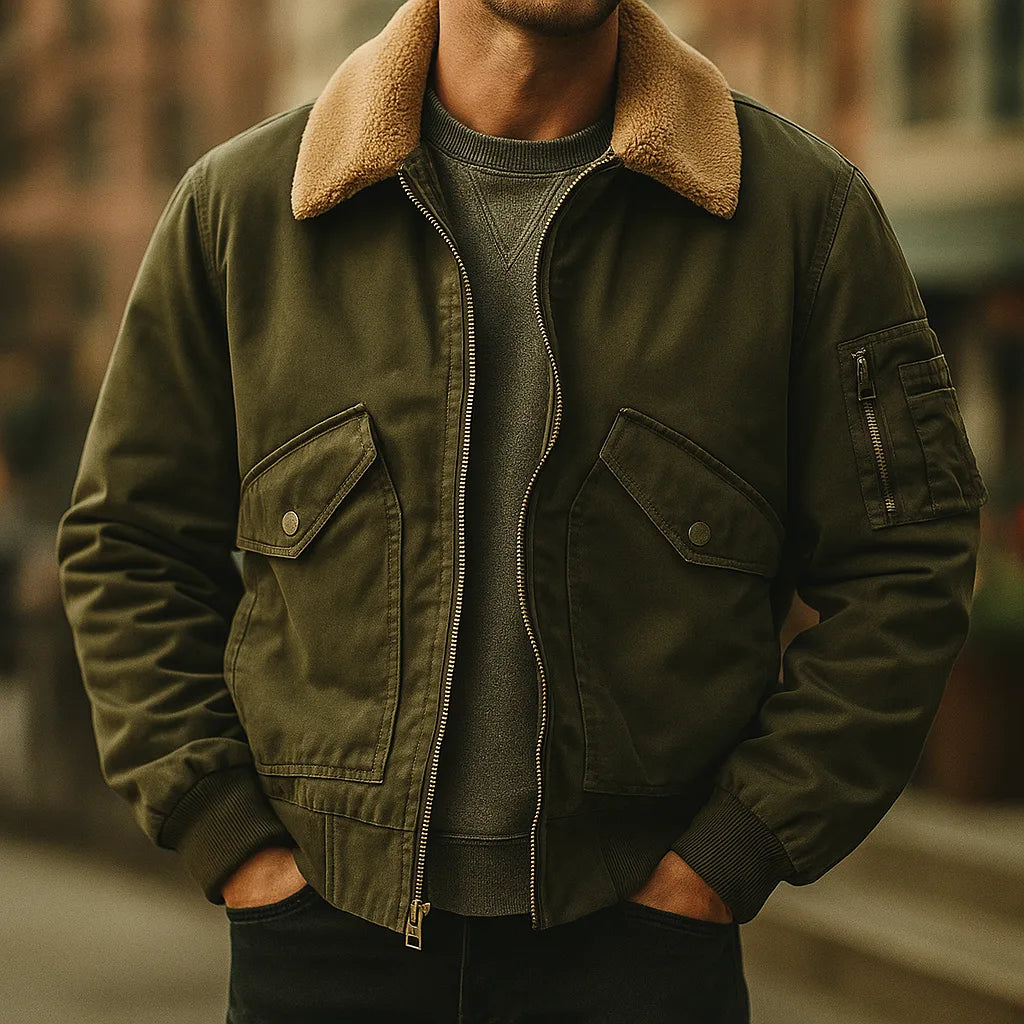 Front view of olive green cotton bomber jacket with shearling collar worn open over a grey jumper