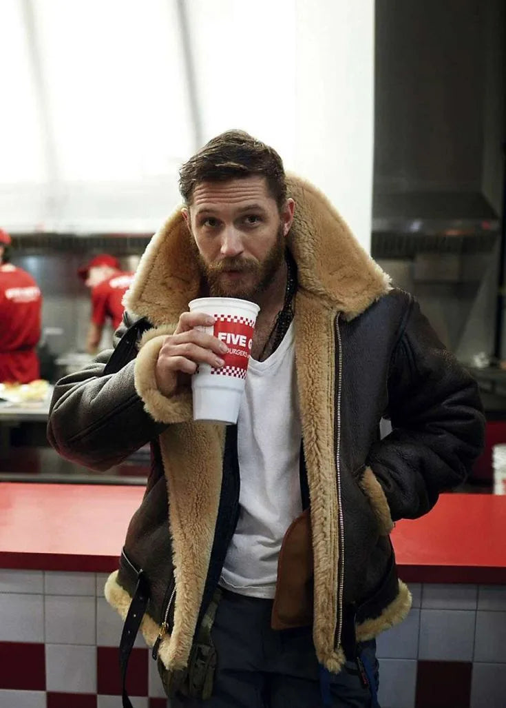 Close-up front view showing the tan shearling collar and lining of a brown leather flight jacket worn open over a white t-shirt
