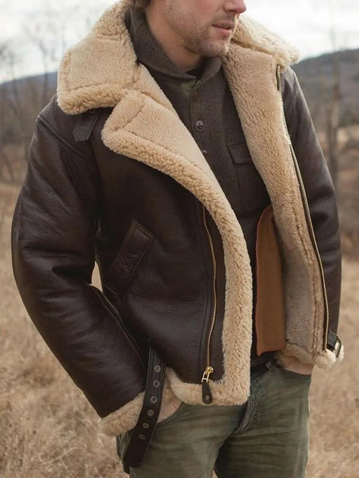 Three-quarter view of a man wearing the open shearling-lined leather jacket with hand in trouser pocket, outdoors in a field