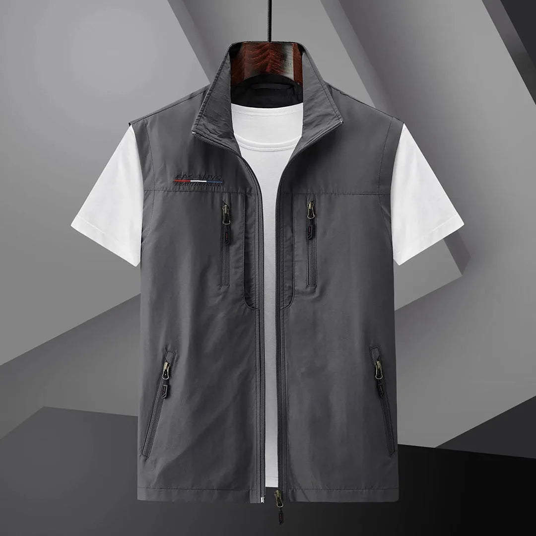 Grey sleeveless zip-up gilet with stand collar, shown fully zipped open with side and chest pockets visible