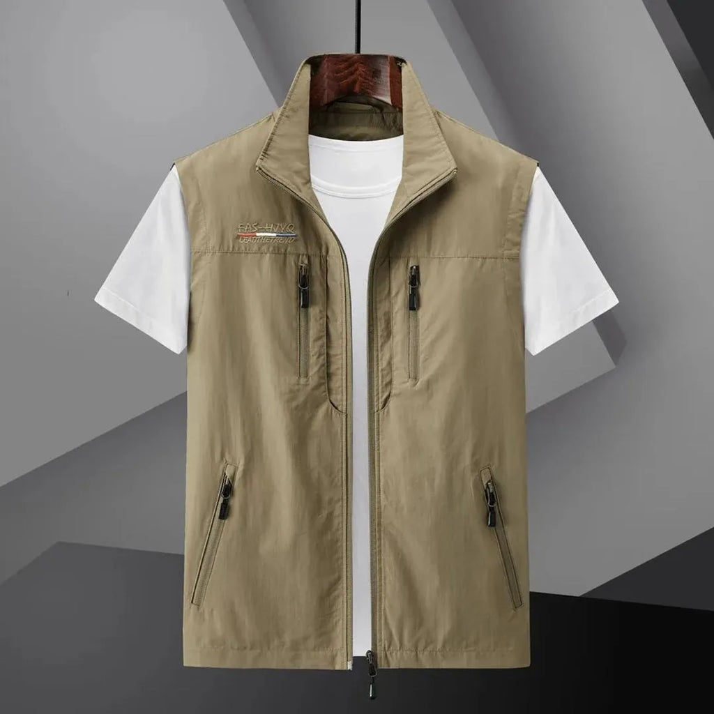Khaki sleeveless zip-up gilet with stand collar and zip pockets, laid out open over a white t-shirt on a hanger