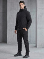 Side angle of the black hooded softshell jacket with multiple zip pockets on the sleeve and chest