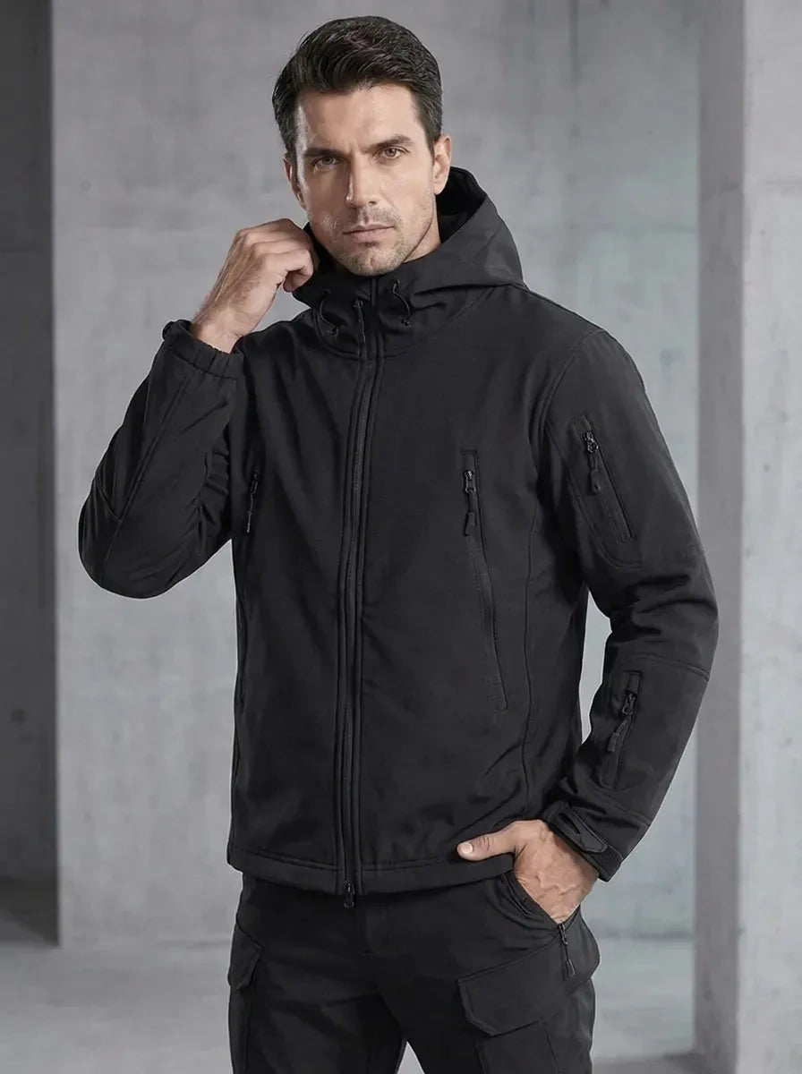 Close-up front view of a man wearing the black hooded jacket zipped up with sleeve pocket detail visible