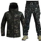 Dark camo softshell jacket paired with matching trousers, worn with tan boots for a full tactical look