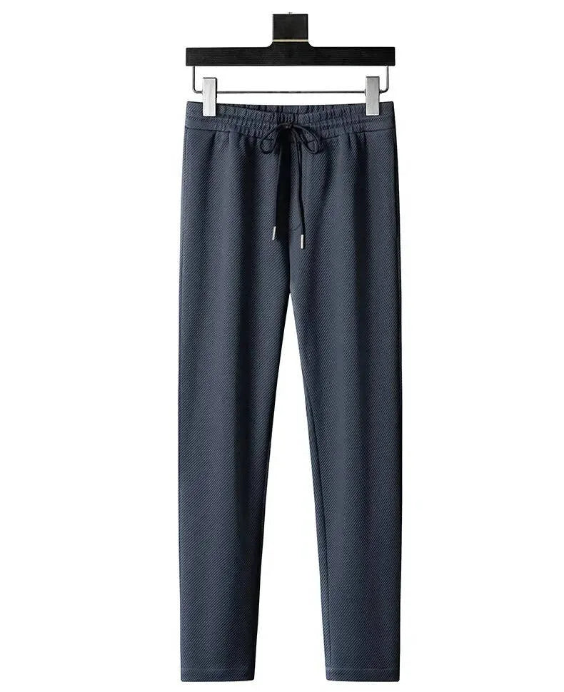 Front view of grey textured tracksuit trousers with elastic drawstring waist and tapered leg