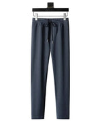 Front view of grey textured tracksuit trousers with elastic drawstring waist and tapered leg