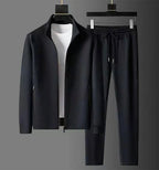 Full black tracksuit set shown together on hangers, zip-up jacket with stand collar and matching trousers