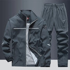 Front view of grey zip-up tracksuit jacket with white trim and matching joggers, mesh lining visible