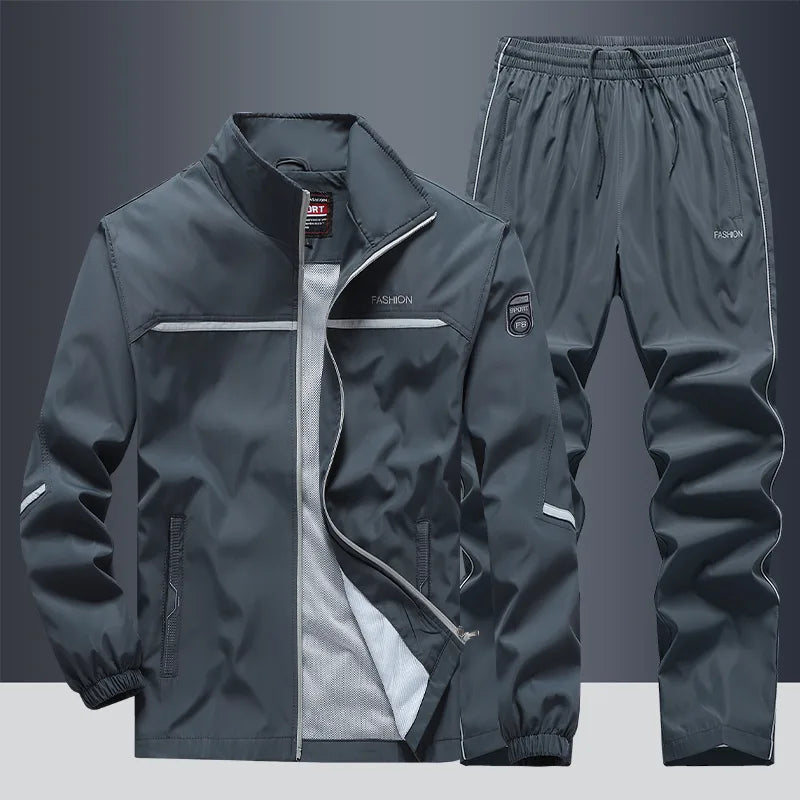 Front view of grey zip-up tracksuit jacket with white trim and matching joggers, mesh lining visible