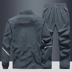 Back view of grey tracksuit jacket and joggers showing reflective stripe detail on sleeve and leg
