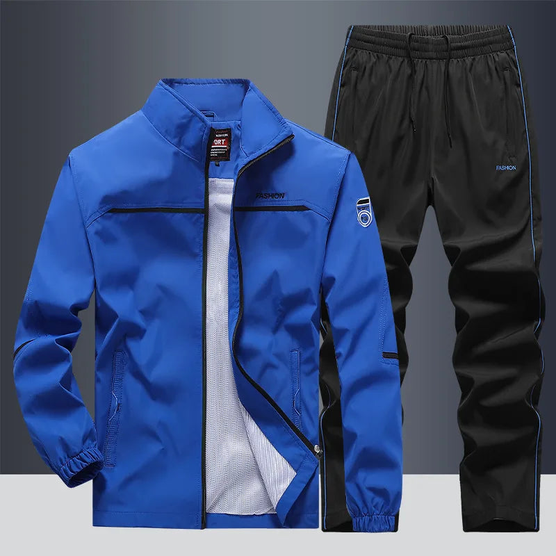 Blue zip-up jacket paired with contrasting black joggers, front view on grey backdrop