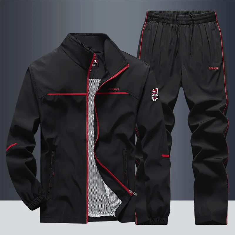 Black tracksuit set with red piping detail along jacket and joggers, zipped jacket front view