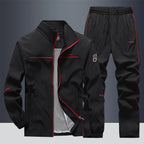 Black tracksuit set with red piping detail along jacket and joggers, zipped jacket front view