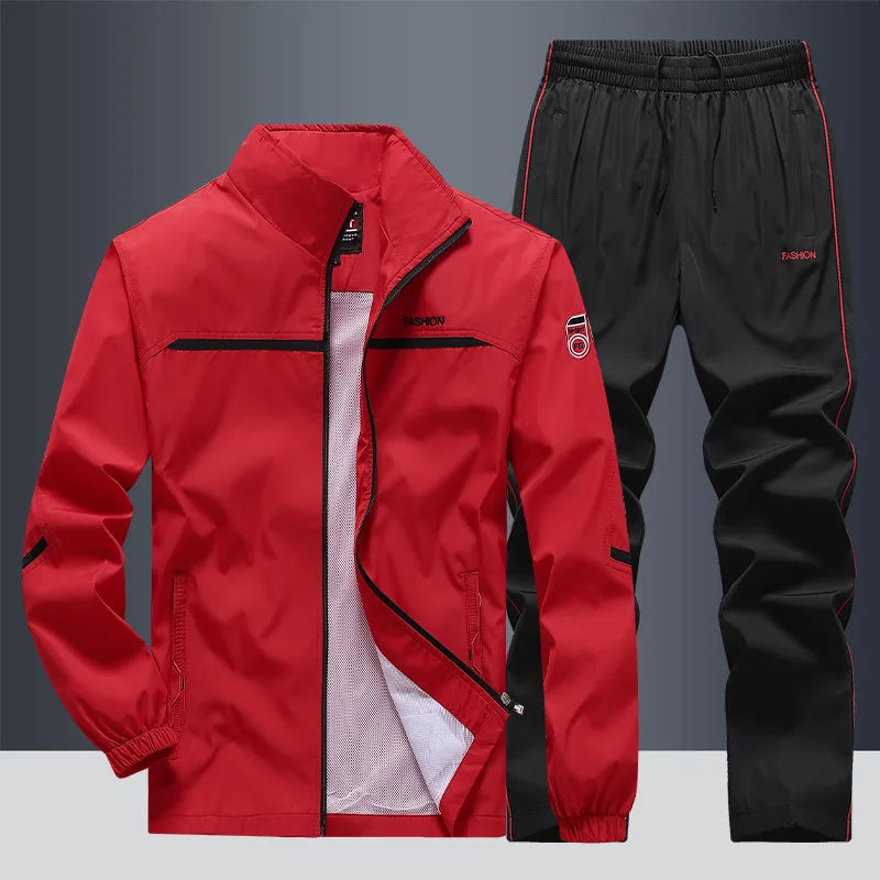 Red zip-up jacket with black trim worn with black piped joggers, front view on grey backdrop