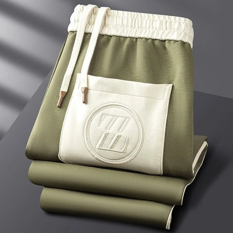 Side view of the striped sleeve detailing and ribbed cuff on the folded brown tracksuit jacket