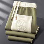 Side view of the striped sleeve detailing and ribbed cuff on the folded brown tracksuit jacket