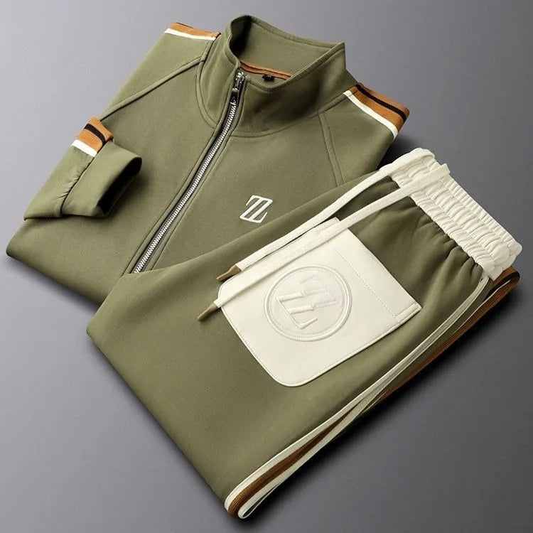 Folded olive green tracksuit set with striped collar trim and cream embroidered logo pocket on the joggers