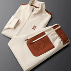 Folded cream tracksuit set with tan trim, stand collar and tonal embroidered logo pocket on the waistband