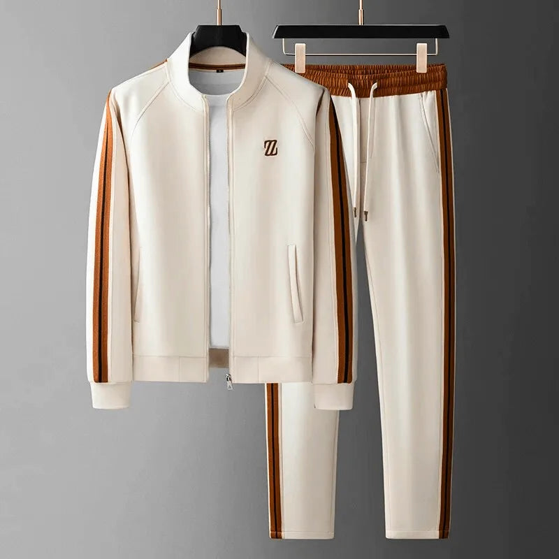 Cream tracksuit on hangers with tan side stripes, zip-front jacket and elastic drawstring joggers