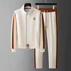 Cream tracksuit on hangers with tan side stripes, zip-front jacket and elastic drawstring joggers