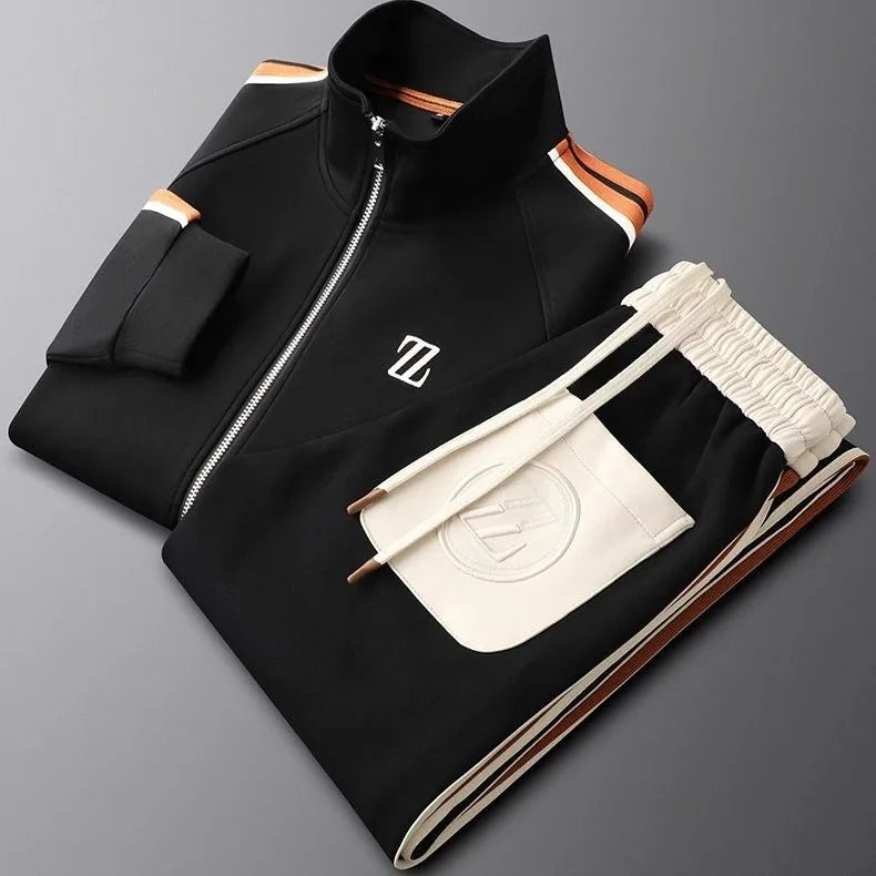 Folded black tracksuit set with orange and white striped collar trim and cream embroidered logo pocket