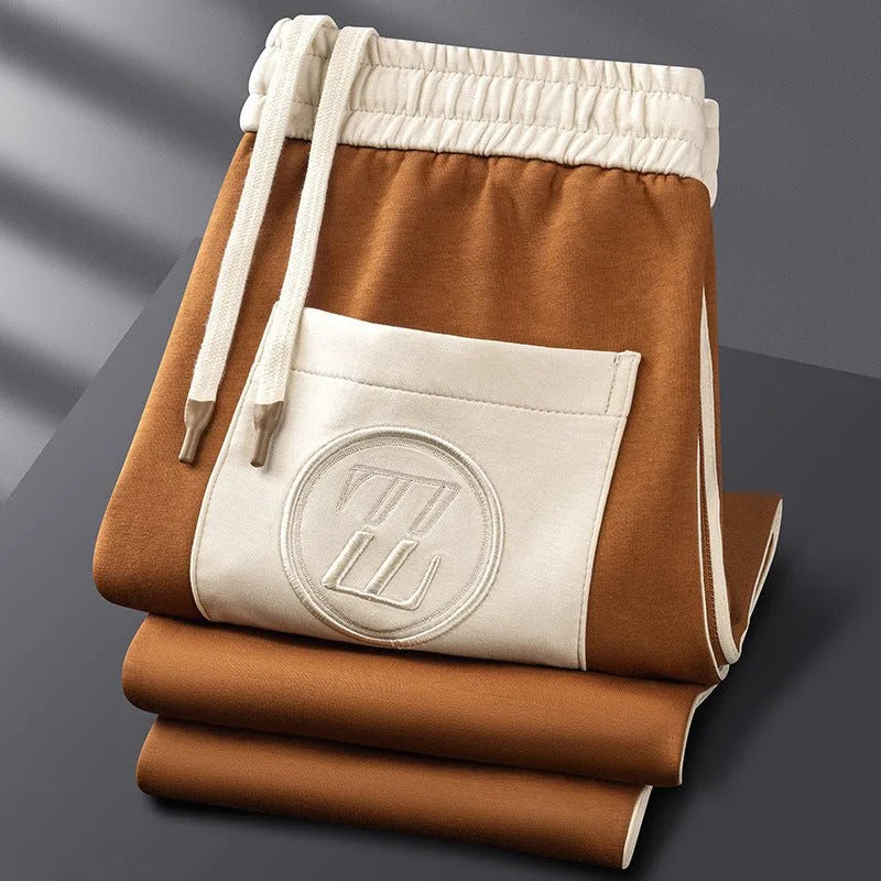 Close-up of the stand collar, zip pull and embroidered Z logo on the chest of the brown jacket