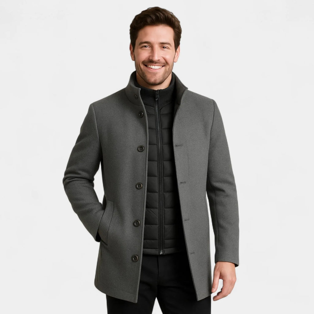 Man in a grey wool-blend coat buttoned to the collar with hands in the side pockets, showing the tailored straight fit