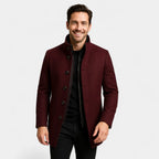 Man wearing a burgundy wool-blend coat open at the front, revealing the black inner gilet and stand-up collar