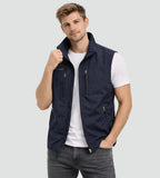Man wearing a navy zip-up gilet with stand collar over a white t-shirt, front view with hand raised to collar