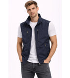 Navy gilet with stand-up collar, zip pockets and small tricolour tab detail, worn open over a white t-shirt