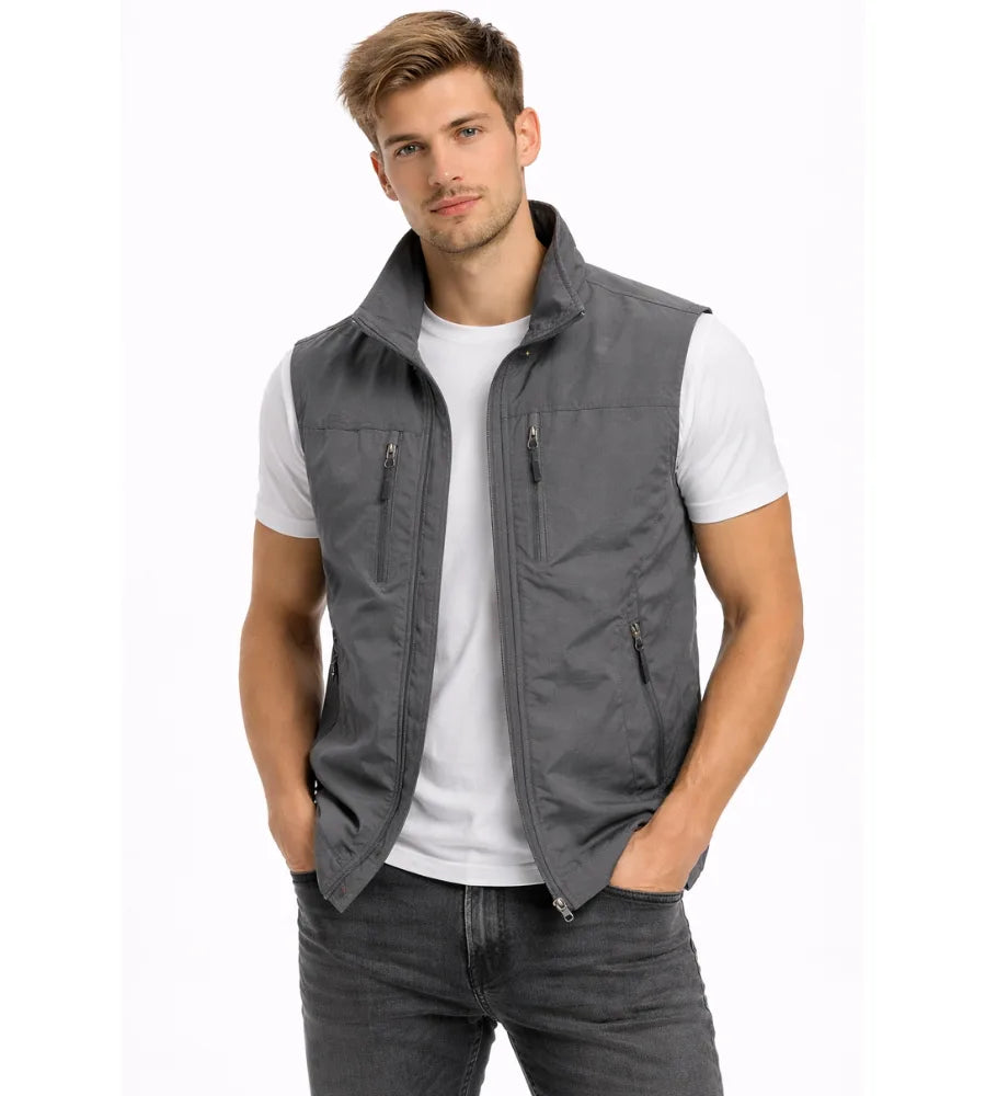 Grey zip-front gilet with stand collar and multiple zip pockets, worn open over a white t-shirt and jeans