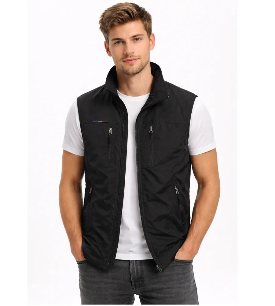 Black zip-up gilet with stand collar and chest zip pockets, worn over a white t-shirt, front close-up view