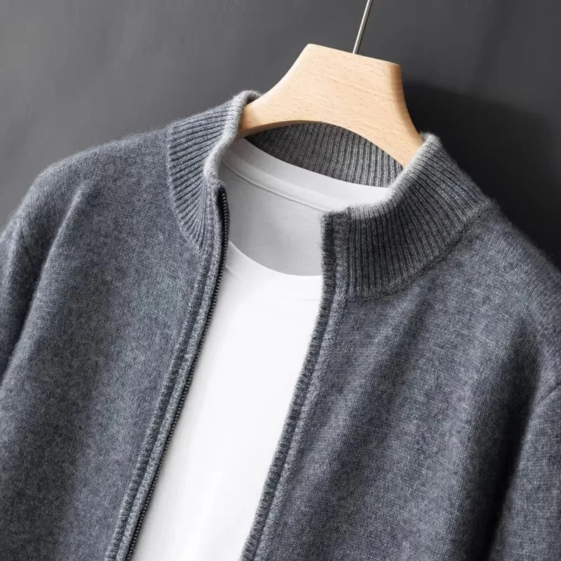 Close-up of grey zip cardigan on wooden hanger, ribbed stand collar and zip pull over white tee