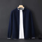 Navy blue cardigan with grey trim collar and cuffs, full front view hanging against dark backdrop