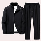 Black full-zip tracksuit jacket with stand-up collar layered over a white t-shirt, shown with matching black joggers